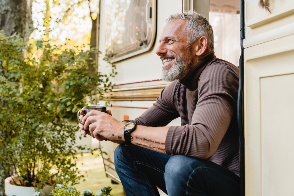 Smiling retired man sitting outside an RV