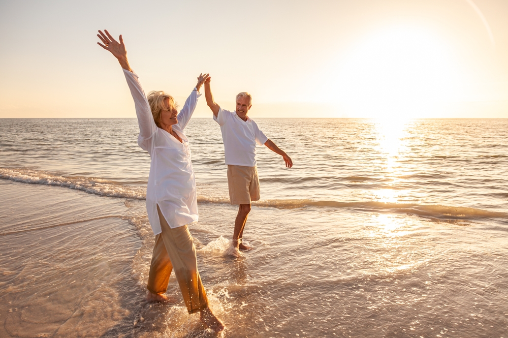 Smiling older couple walking in the ocean